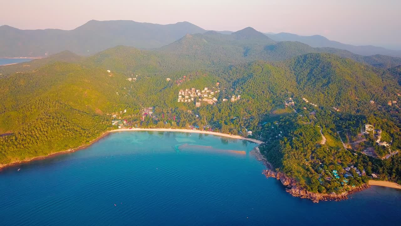 4k 공중 드론은 어선, 청록색 물, 산호 및 녹색 정글이 있는 태국 코팡안에 있는 샐러드 해변을 앞으로 밀어냅니다.