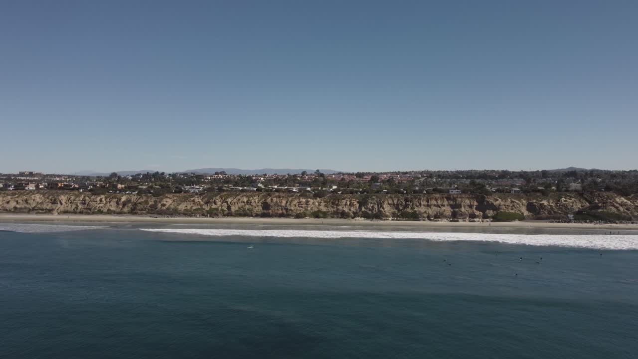 아름다운 공중 드론 샷, 해안을 향해 날아가는 드론, 배경에 산이 있는 동네, 칼즈배드 주립 해변 - 캘리포니아