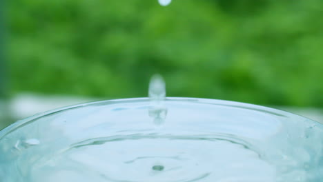 close-up of tiny droplets of water creating ripples and waves in a glass full of water