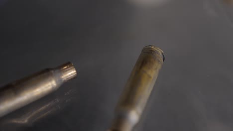 bullet shells falling onto a smokey surface