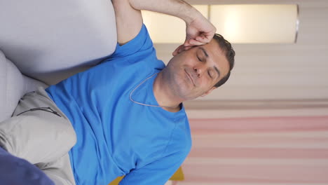 el video vertical del hombre acostado en el sofá está descansando.