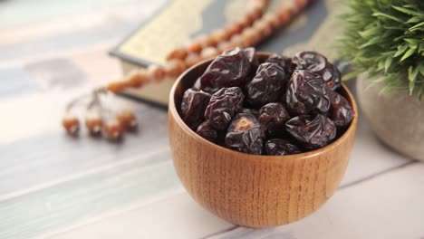 dátiles secos en un cuenco de madera con artículos religiosos