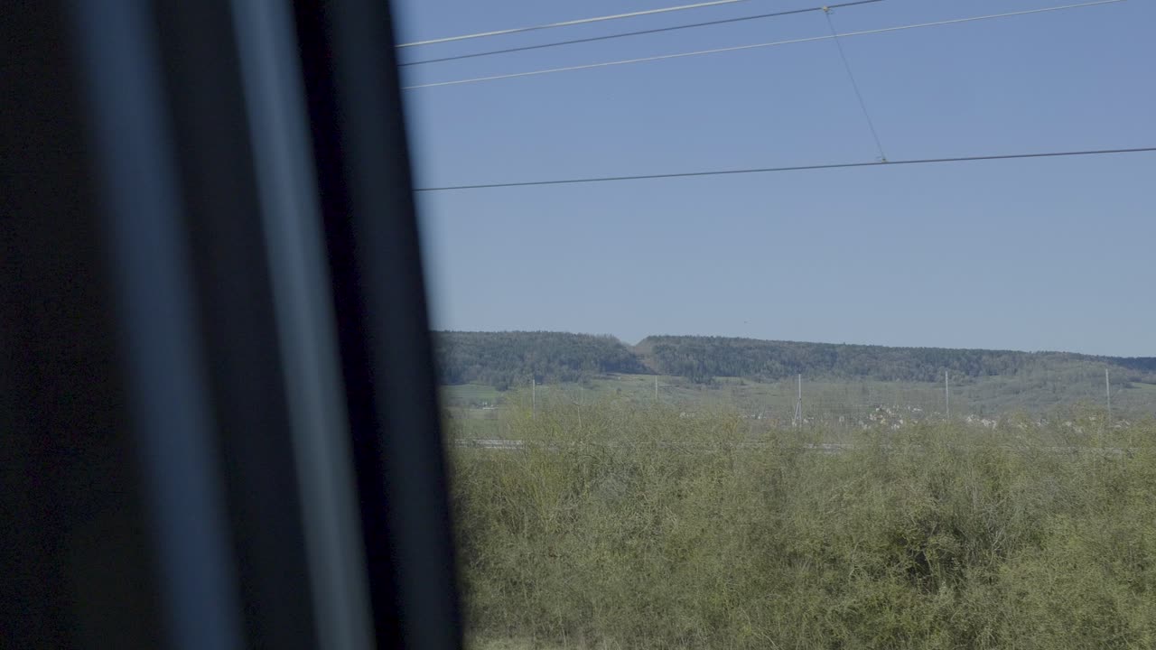 Train journey through a landscape, captured from the point of view of a passenger