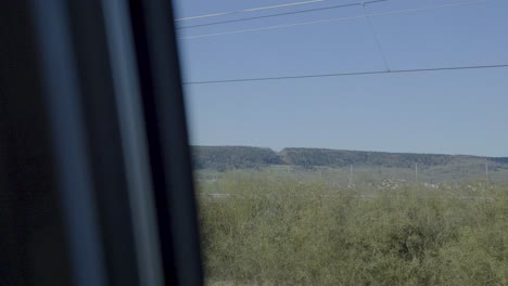 train journey through a landscape, captured from the point of view of a passenger
