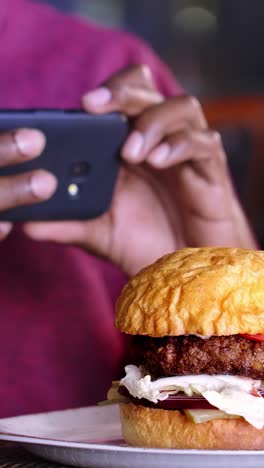 taking a picture of a burger