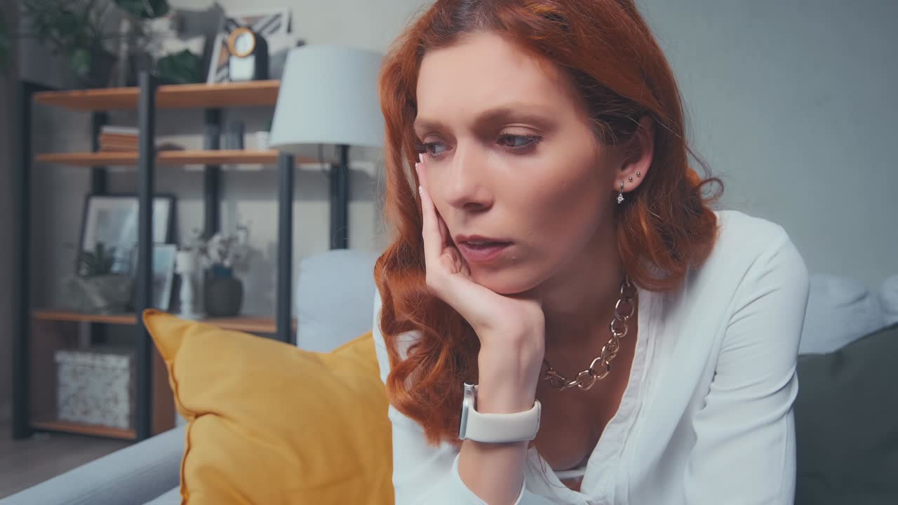 Primo piano di una donna depressa che pensa a problemi psicologici guardando altrove, da sola