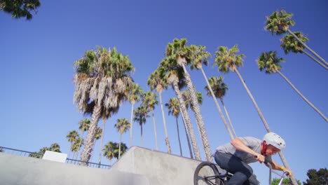 low angle view of a bmx bike rider executing a jump at a skatepark