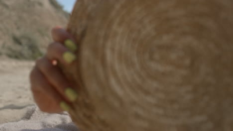 positive girl playing beach covering camera with hat close up. woman lying sand.