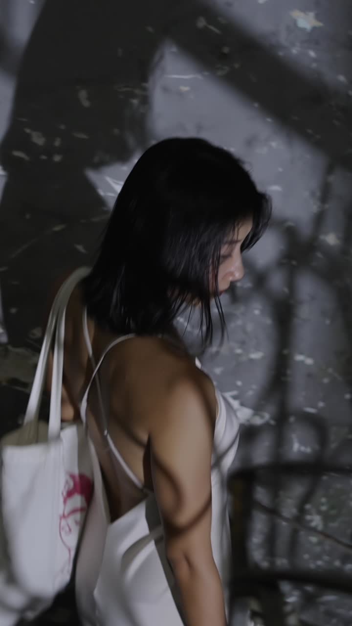 A woman in a dress stands in an indoor environment