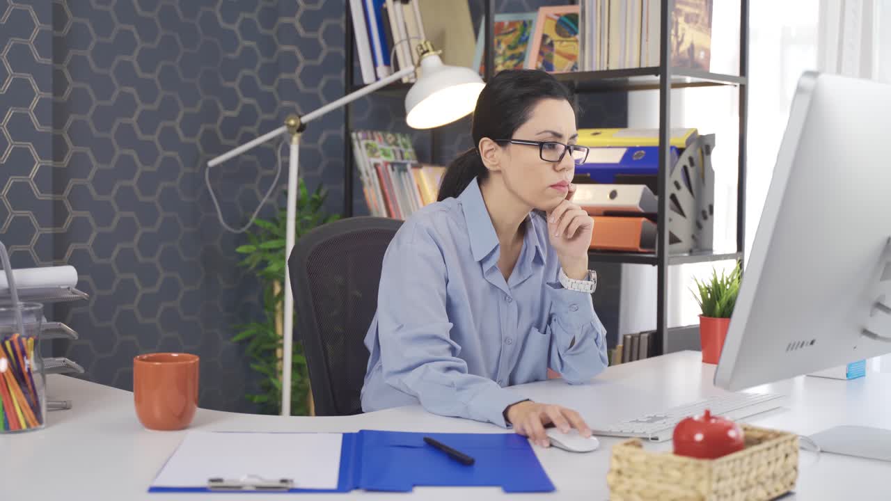 Business woman in glasses working with computer in office.