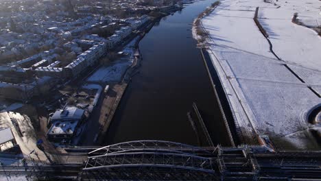 from steel draw bridge to snow covered floodlands and countenance of zutpen along the river ijssel in the netherlands