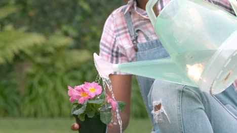 mujer sonriente regando las plantas