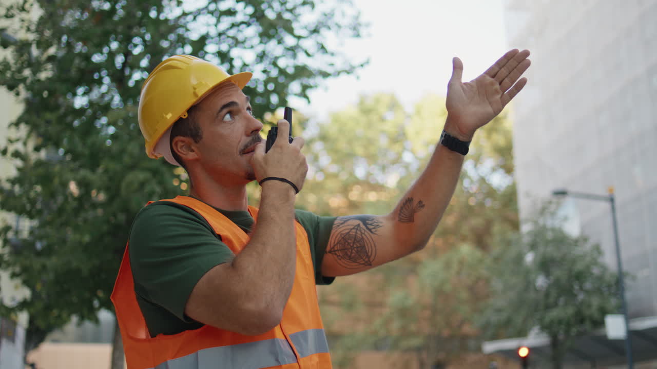 Skilful foreman dictate instructions using portable radio at street closeup