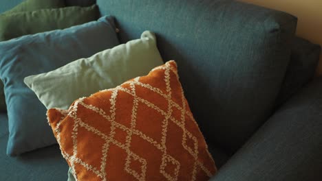 closeup of blue sofa with colorful throw pillows