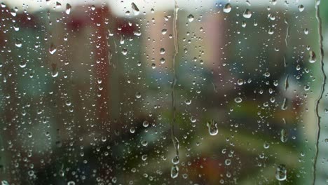 droplets on glass during rain. raindrops falling on the window on blur background outside. wet weather. close-up.