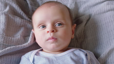 portrait happy baby looking curious infant lying on blanket