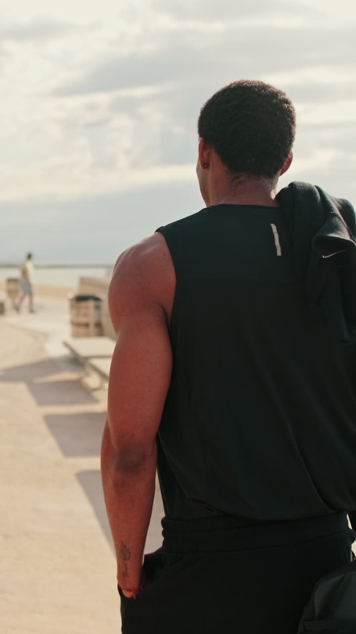 Fit Black Man Walks to the Beach for a Workout