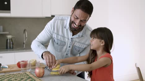 joyful dad and daughter enjoying cooking together