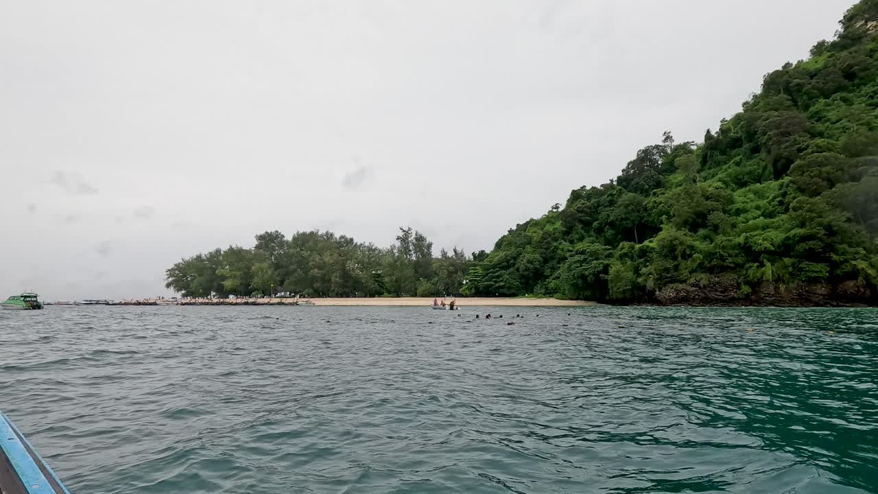 el barco se acerca a la isla exuberante en krabi, tailandia.