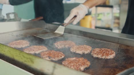 Man-Grilling-Burger-Patties-on-a-Large-Grill-Top