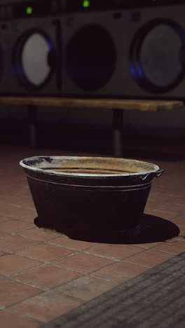 a rusty metal bucket in a laundry room