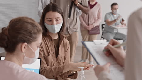 unrecognizable medic measuring temperature of visitors