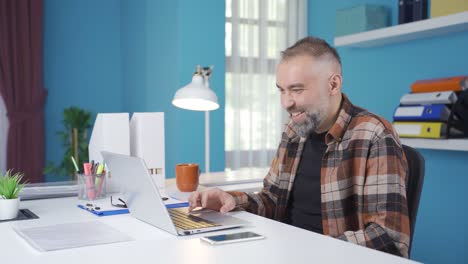 Cheerful and funny businessman is using laptop.