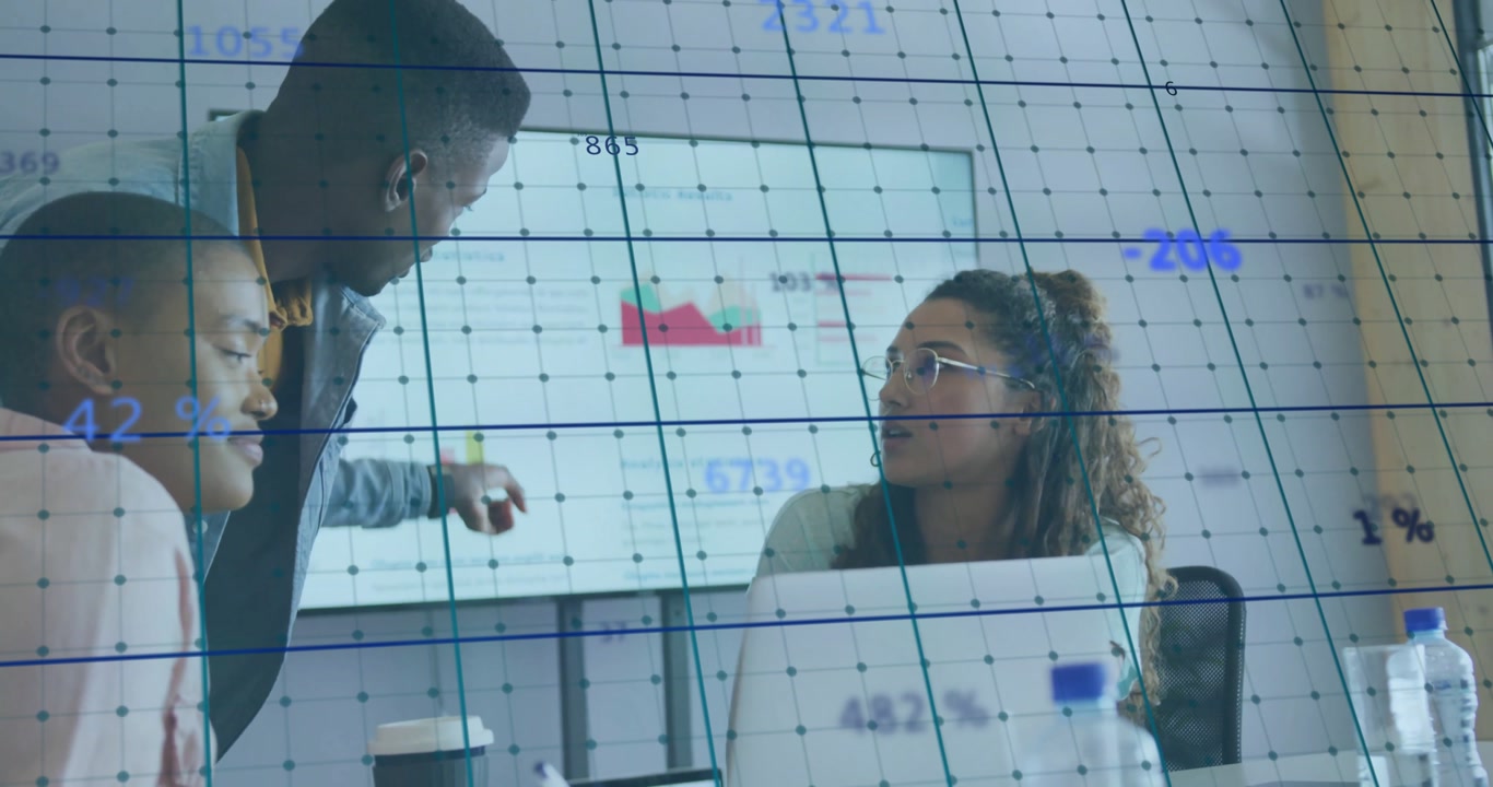 Colleagues reviewing laptop data, man pointing at red graph on wall screen for business plan