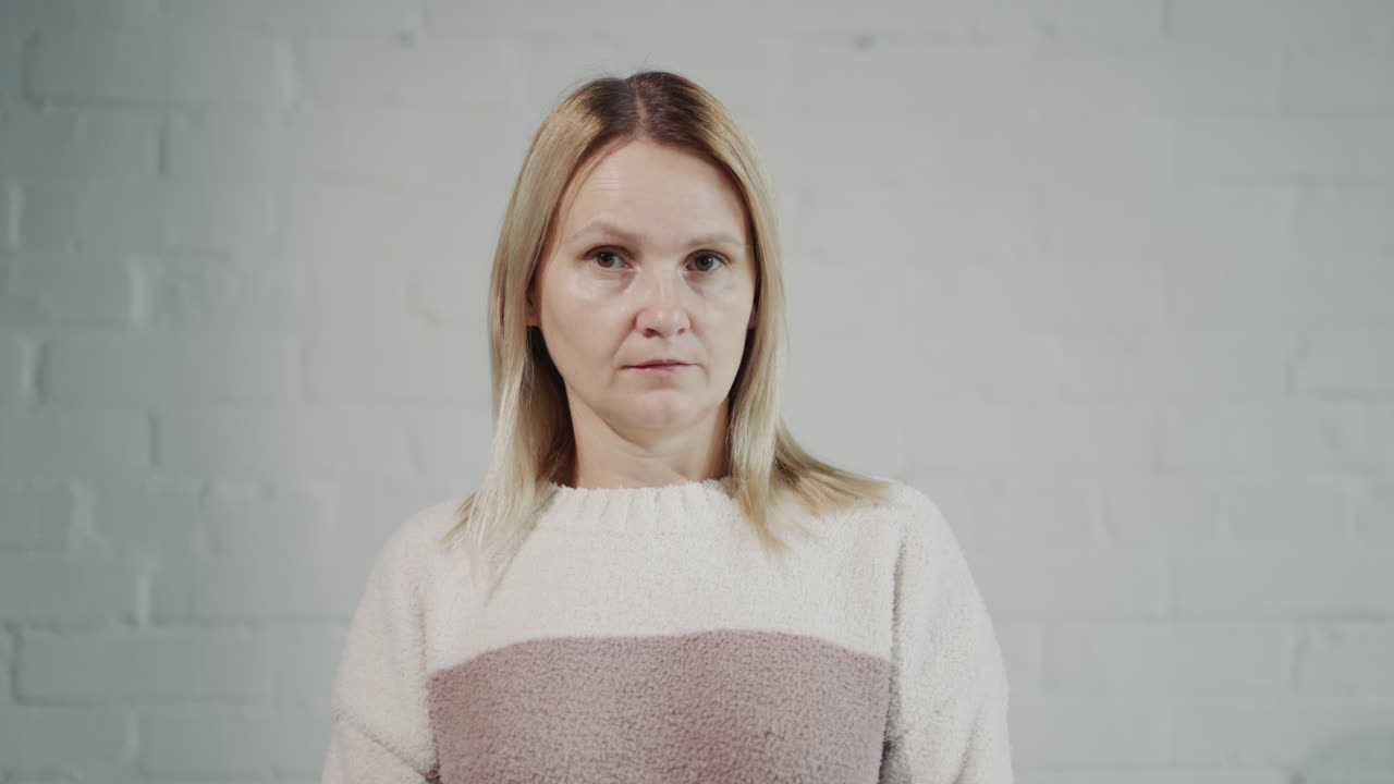 mujer de mediana edad mirando su cabello en el espejo. video 4k