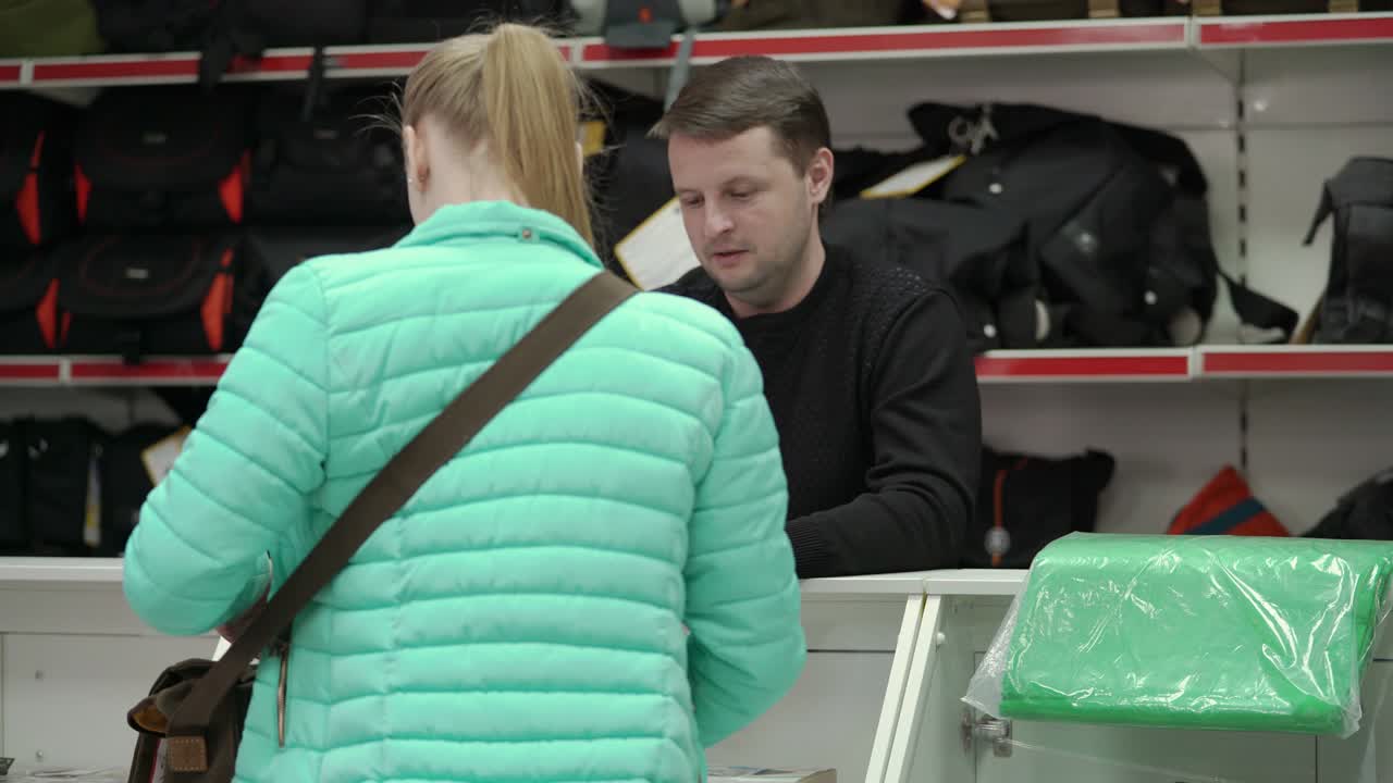 Photographer choosing camera bag in photography and camera shop