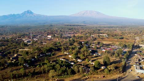 amanecer paisaje de kenya con una aldea, kilimanjaro y parque nacional de amboseli - seguimiento, vista aérea de avión no tripulado