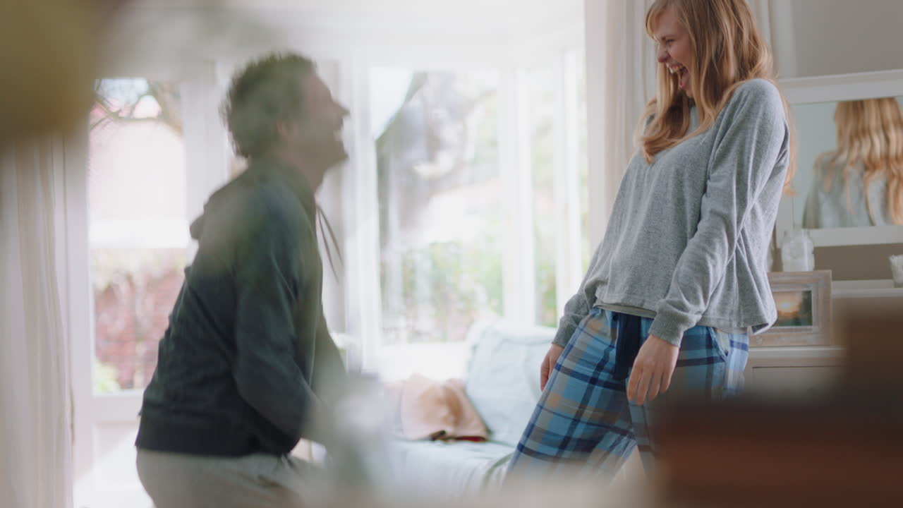 pareja joven feliz bailando en casa celebrando divirtiéndose fin de semana por la mañana juntos disfrutando de un divertido baile en el dormitorio celebración de una relación exitosa 4k footage