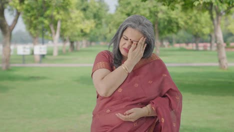 Sick-Indian-old-woman-having-a-headache-in-park