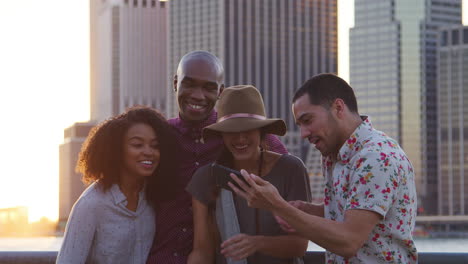 group of friends posing for selfie in front of manhattan skyline