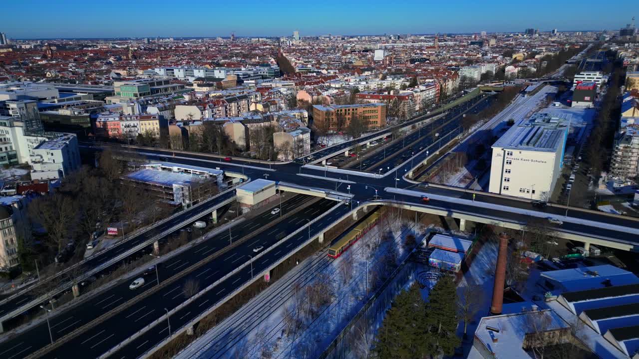 Panoráma Berlína shora během zimního dne, ukazující komplexní silniční síť, dopravní tok, železniční tratě a budovy. Krásný panoramatický letecký pohled z dronu s orbitálním obletem.