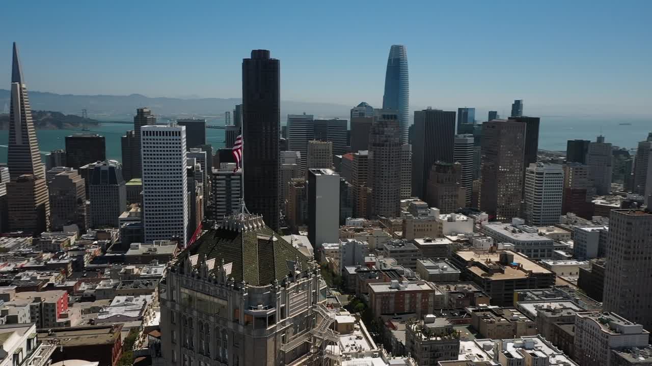 Drone captures breathtaking aerial footage of San Francisco's skyline under clear blue skies, highlighting iconic skyscrapers and bustling urban life in dynamic daylight