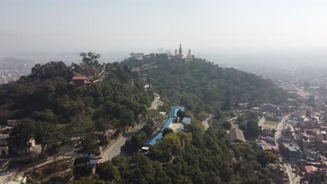 Flying-over-the-populated-city-of-Kathmandu,-Nepal-with-a-temple-in-the-background