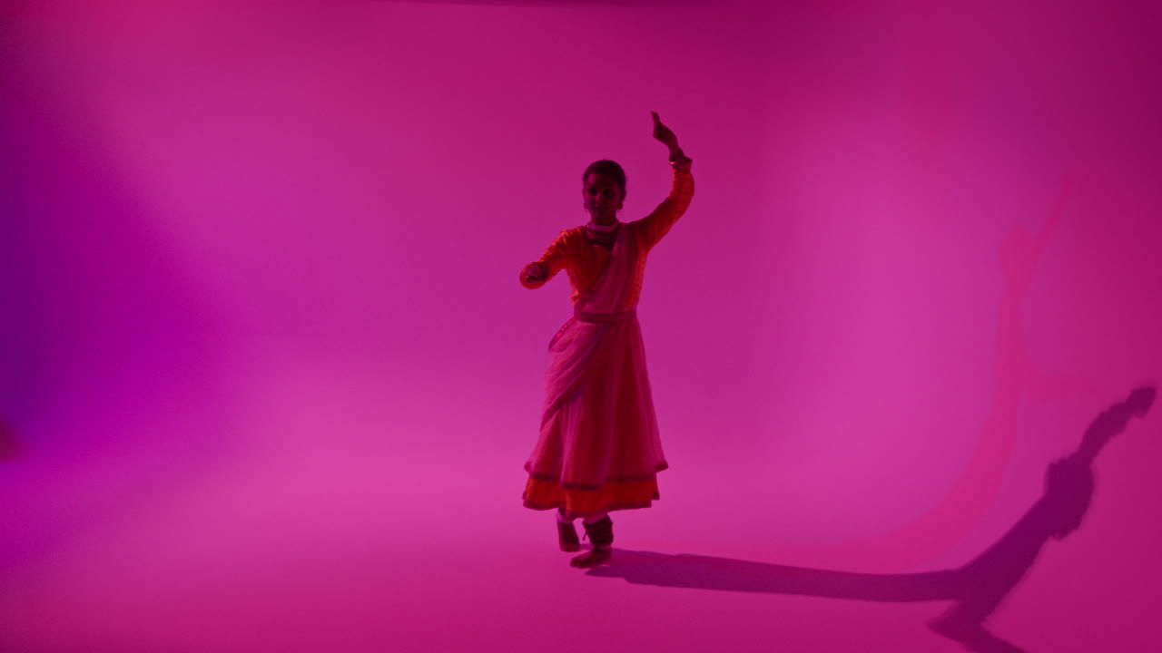 la cámara se mueve a través del equipo del estudio para mostrar a una bailarina de kathak vestida con el vestido tradicional indio bailando