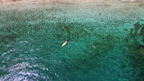 Toma-Aérea-De-Arriba-Hacia-Abajo-De-Un-Remero-En-El-Mar-Egeo-Turquesa,-Playa-De-Andros,-Cícladas,-Grecia