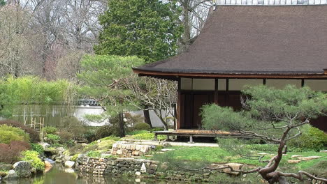 corner of a japanese house with stone walls edging a pond