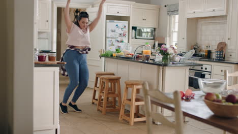 chica adolescente con sobrepeso feliz bailando en la cocina divirtiéndose celebrando el fin de semana realizando movimientos de baile divertidos en casa disfrutando de la celebración del fin de semana