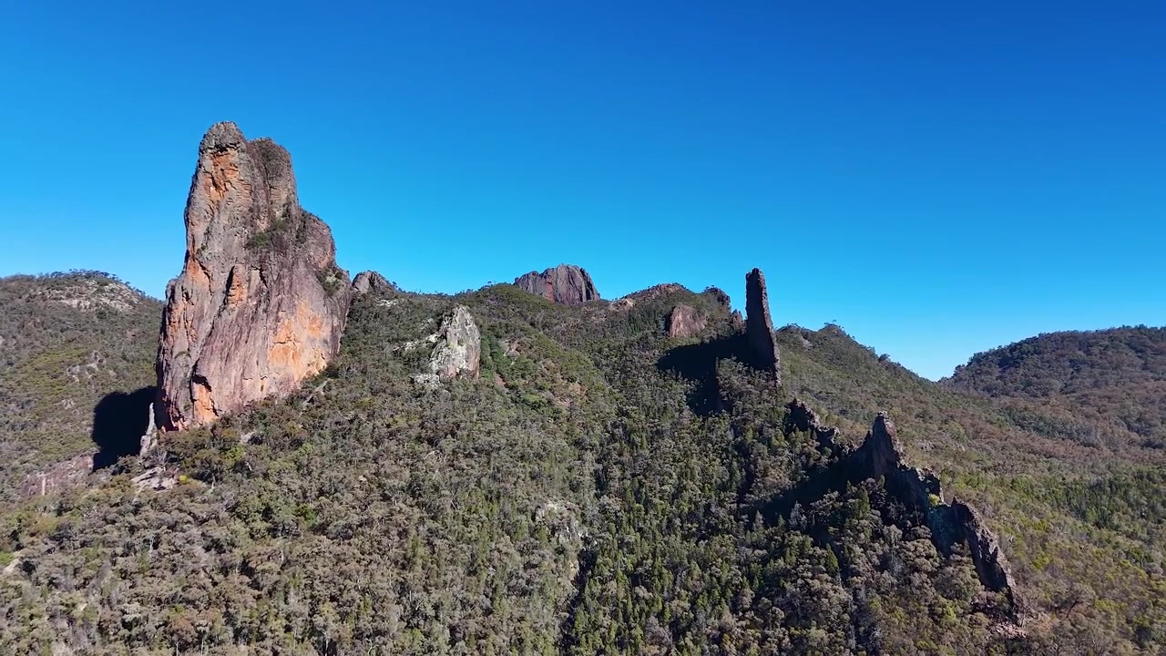 Amplia toma aérea de formaciones rocosas volcánicas bajo un cielo azul claro en el Parque Nacional Warrumbungle