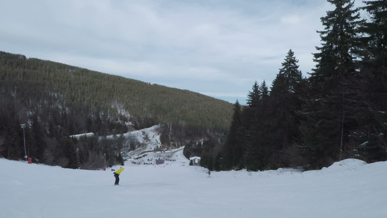 People skiing down a snowy mountain slope at a ski resort