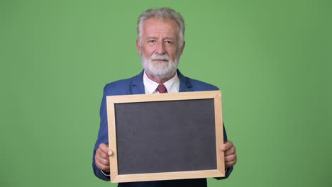 hombre de negocios barbudo y guapo contra un fondo verde.