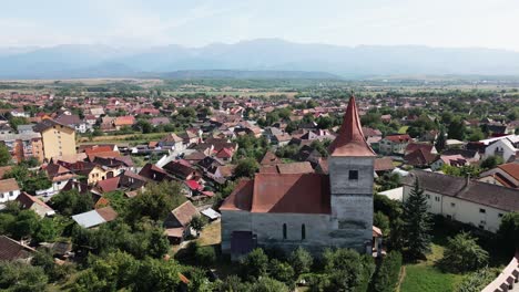 church in a romanian village with beautiful mountains in the background, carpathians, romania, europe, drone, summer