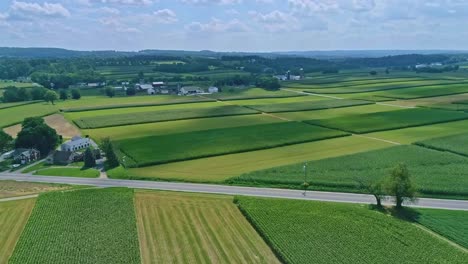 Una-Vista-Aérea-De-Los-Campos-De-Maíz-Y-La-Cosecha-De-Cultivos,-Con-Manchas-De-Color-En-Un-Hermoso-Día-De-Verano