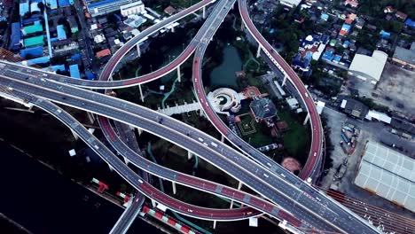 cars driving on roads and circular shaped highways. aerial top view of bhumibol bridge in structure of suspension architecture concept, urban city, bangkok, thailand.