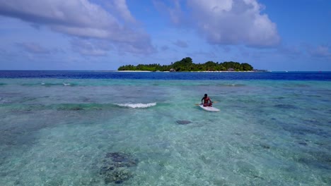 african man paddling in the crystal clear waters in maldives archipelago