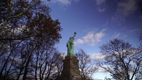 pov walking through trees towards the statue of liberty in new york, usa