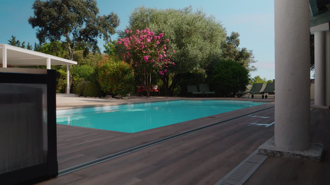 Langsomt stigende optagelse af en farverig privat pool med planter i fuldt flor